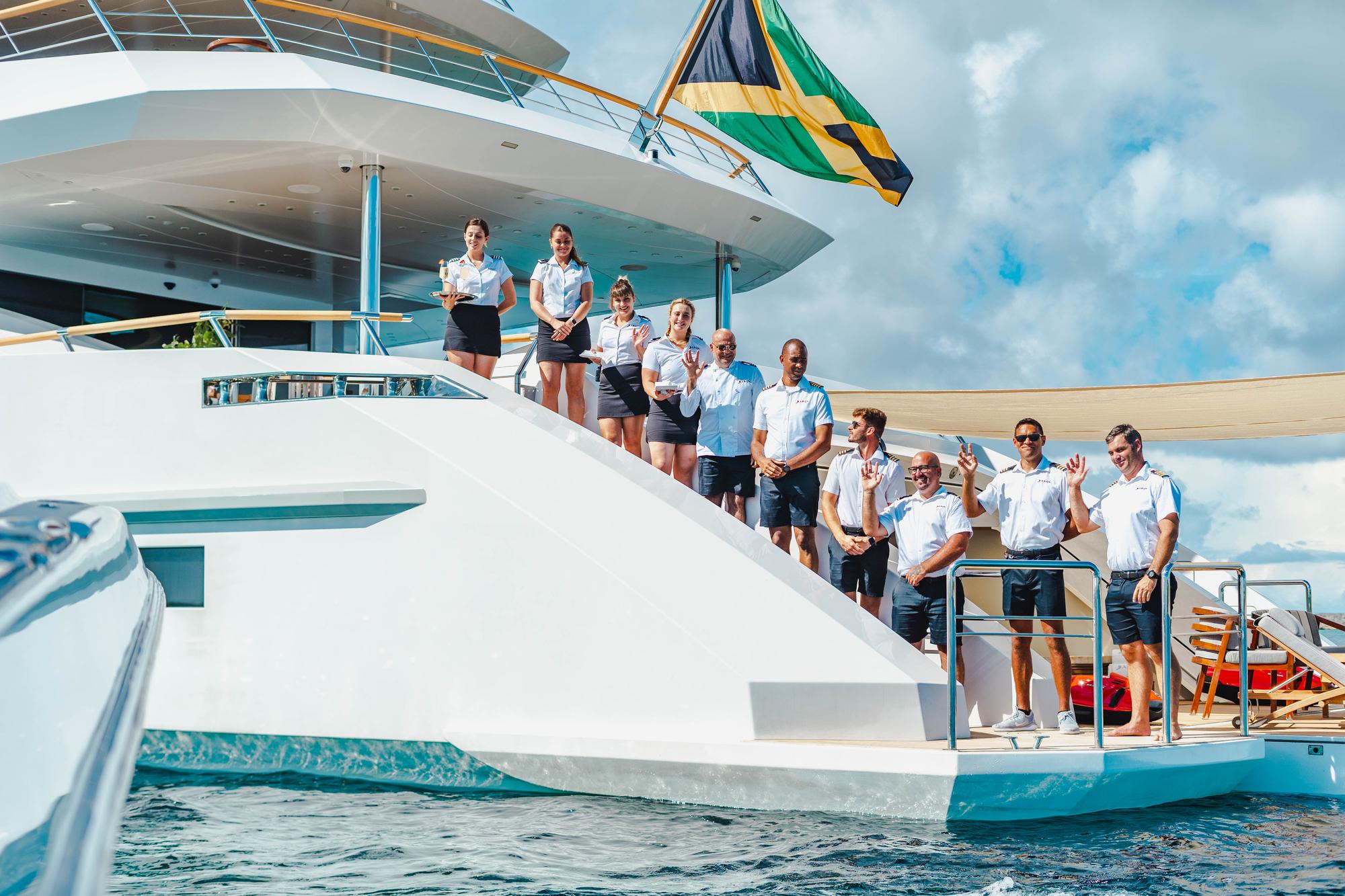 Crew members of the BABAS yacht preparing for the arrival of guests, ensuring a seamless and luxurious boarding experience. | BABAS yacht, yacht crew, guest preparation, luxury hospitality | Fraser Yachts