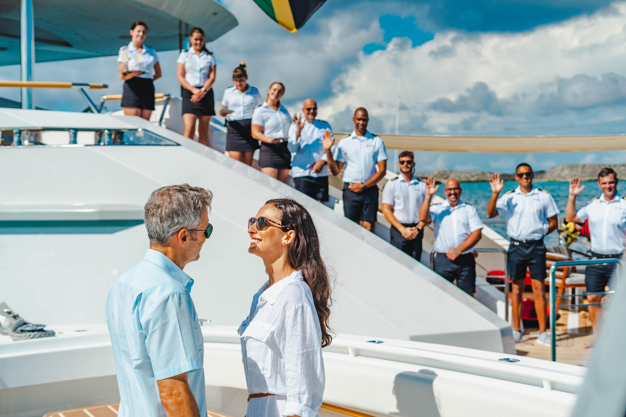 The crew of the BABAS yacht assisting with guest arrival, highlighting professionalism and attention to detail in luxury service. | BABAS yacht, yacht crew, guest arrival, luxury service | Fraser Yachts