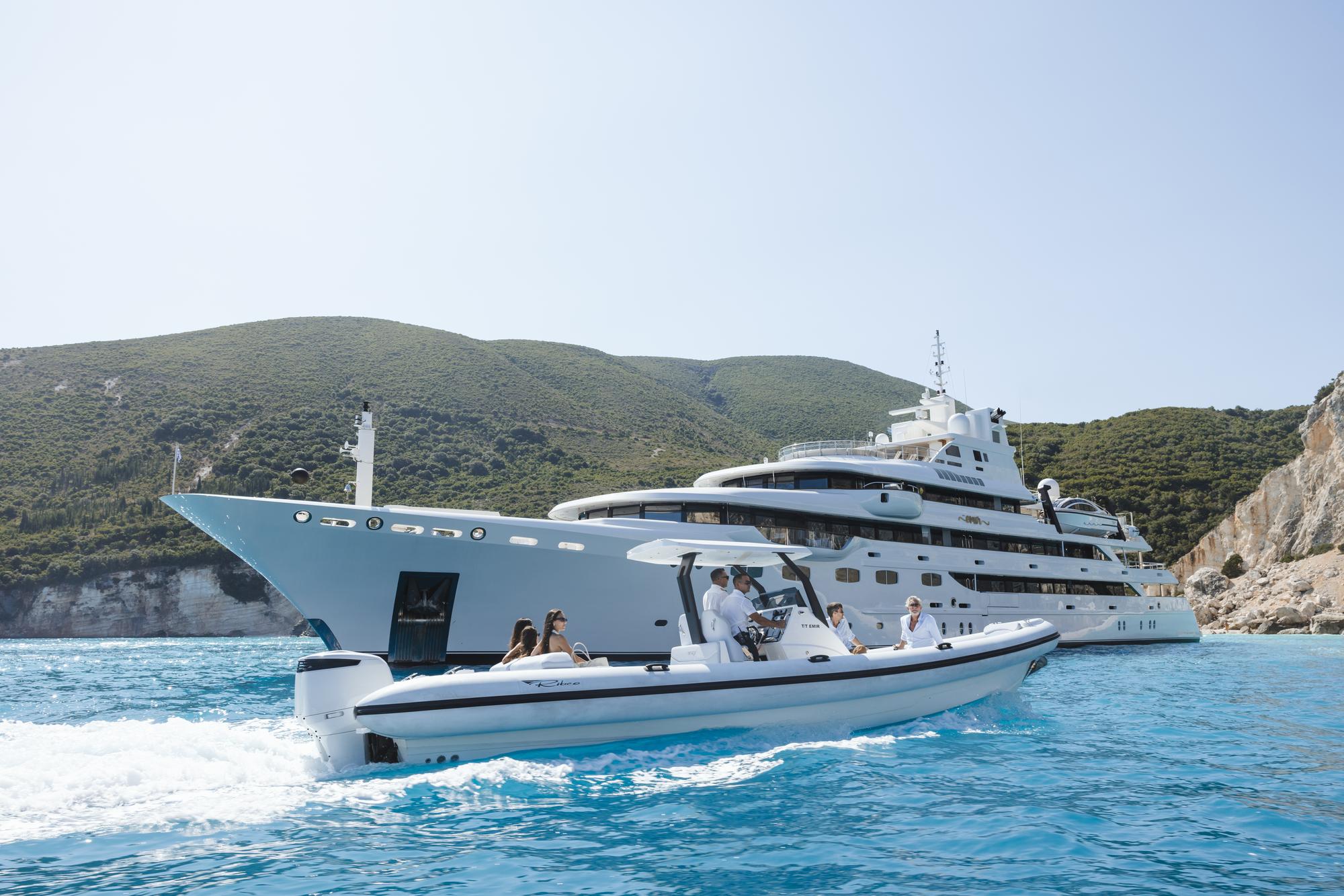 Guests arriving at the EMIR yacht by tender, excitedly stepping off to begin their luxurious experience on board. | EMIR yacht, guest arrival, tender arrival, luxury lifestyle | Fraser Yachts