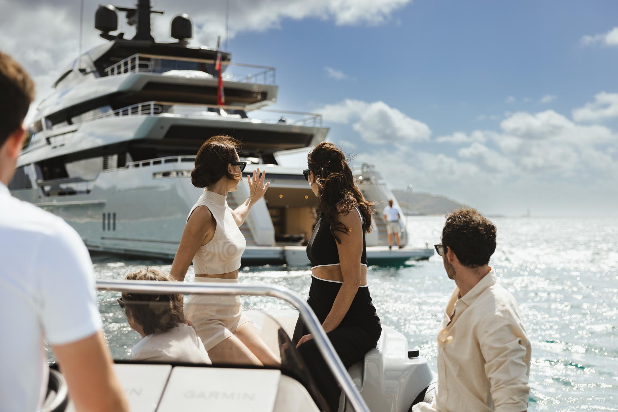Guests arriving at the VIRTUOSITY yacht by tender, excitedly preparing to step aboard for a luxurious experience at sea. | VIRTUOSITY yacht, guest arrival, tender arrival, luxury lifestyle | Fraser Yachts