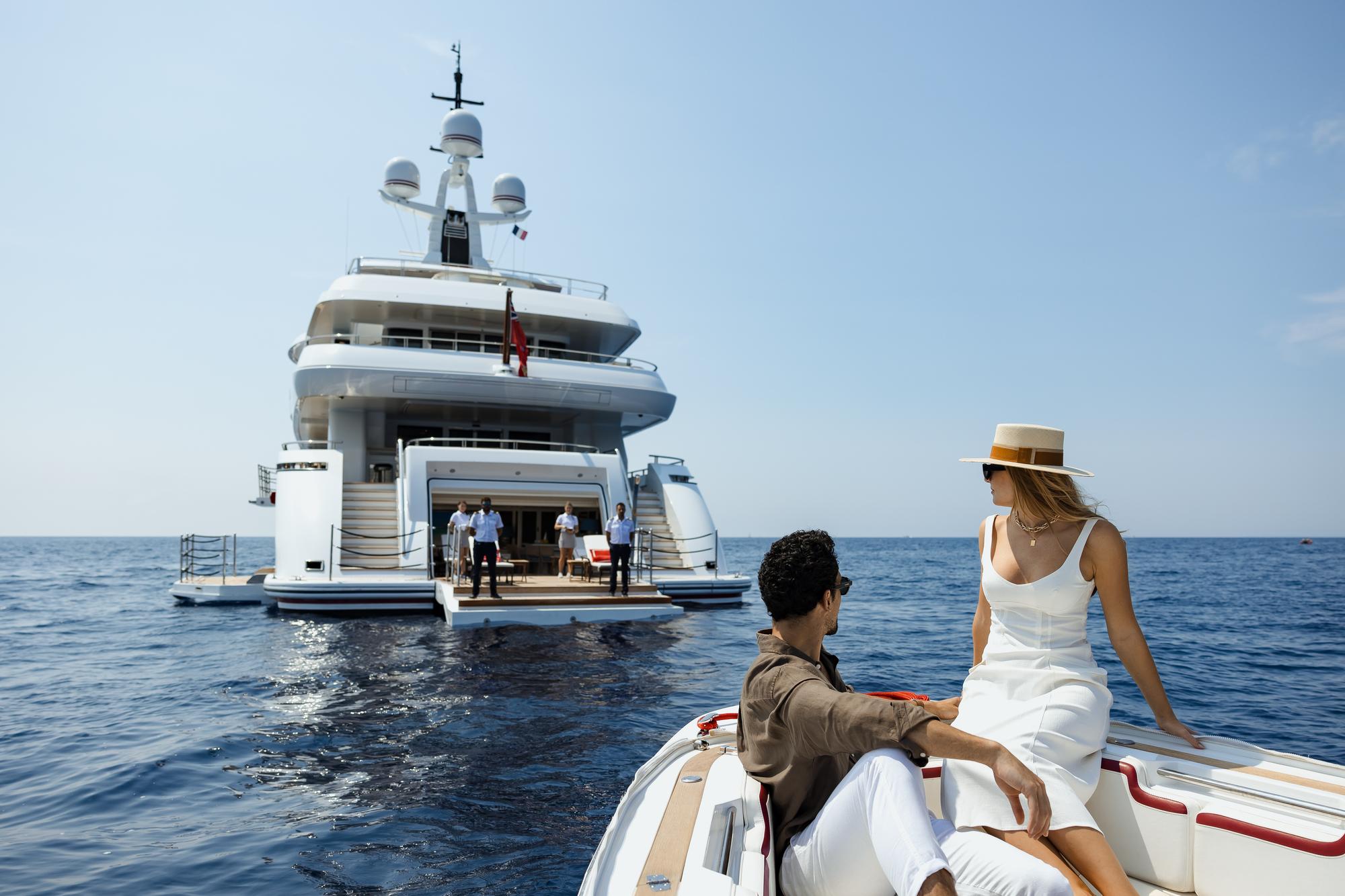 Guests arriving at the EMIR yacht by tender, excitedly stepping off to begin their luxurious experience on board. | EMIR yacht, guest arrival, tender arrival, luxury lifestyle | Fraser Yachts