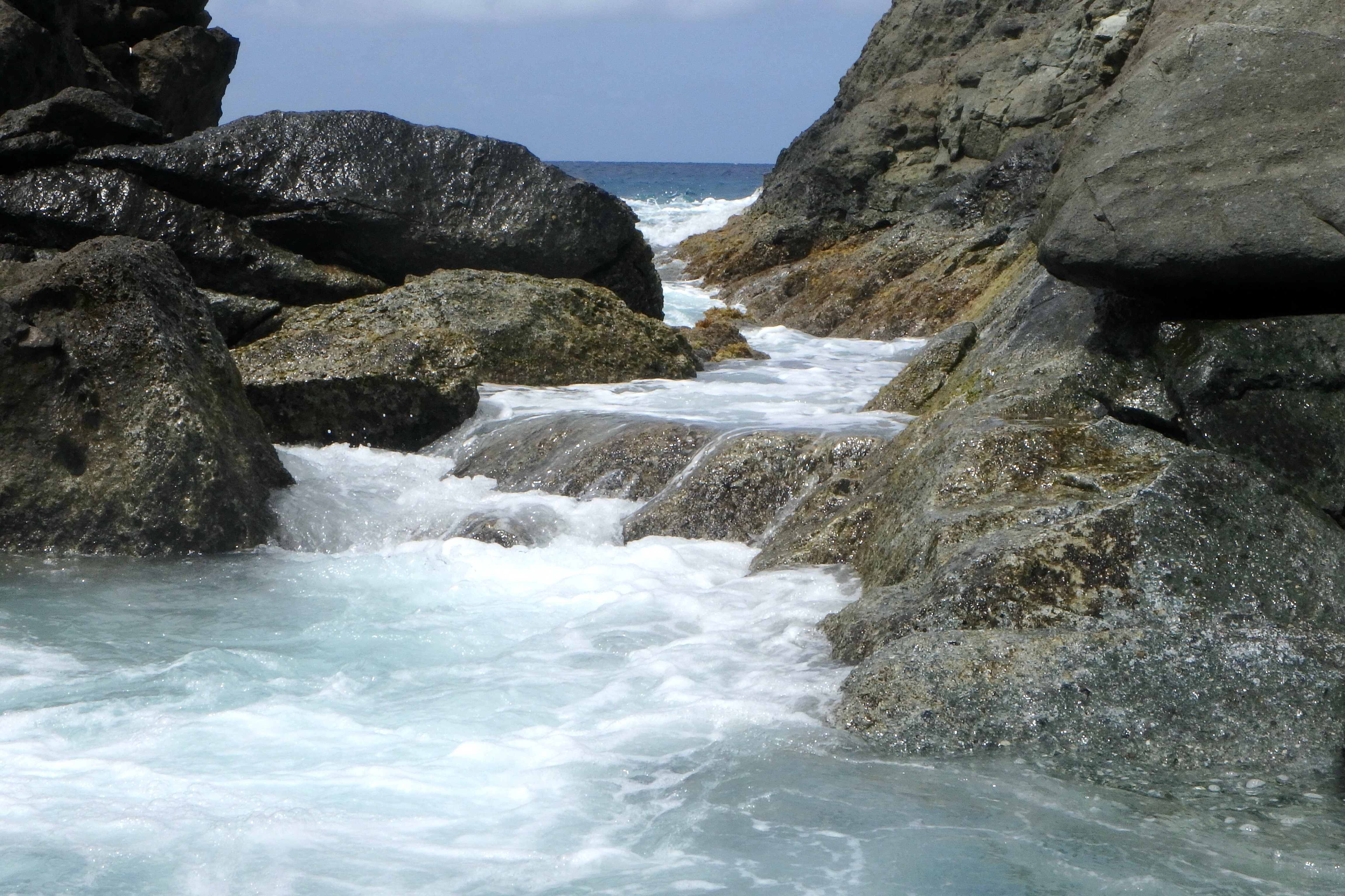 The Bubbly Pool on Jost Van Dyke, BVI—a hidden gem where ocean waves rush through rocks to create a natural jacuzzi, perfect for hiking, swimming, and off-charter adventures | Fraser Yachts
