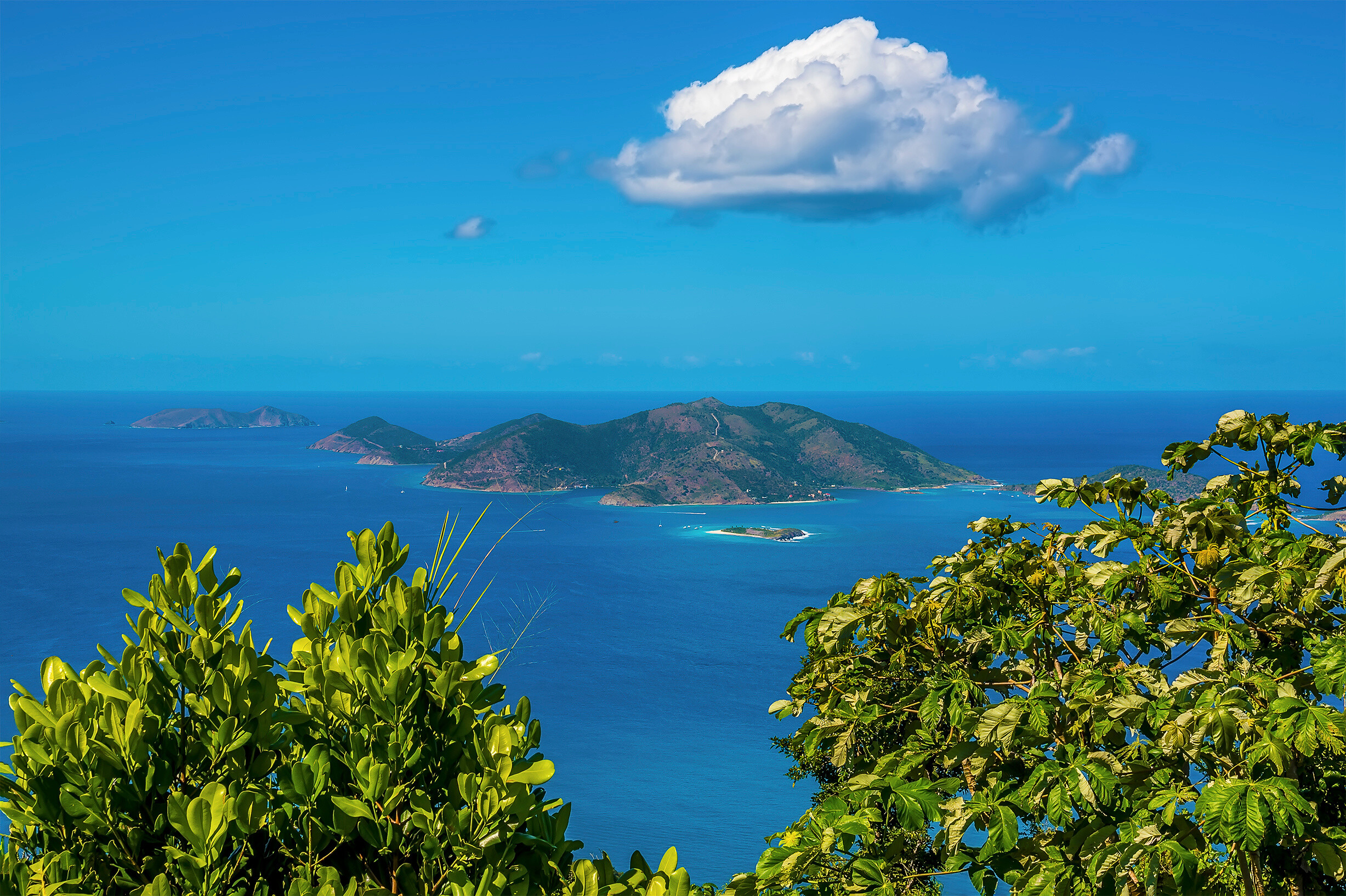 View from Tortola toward Sandy Cay and Jost Van Dyke, BVI—lush ridgelines, blue sea, and quiet islets create a tropical panorama ideal for yacht cruising and island-hopping | Fraser Yachts