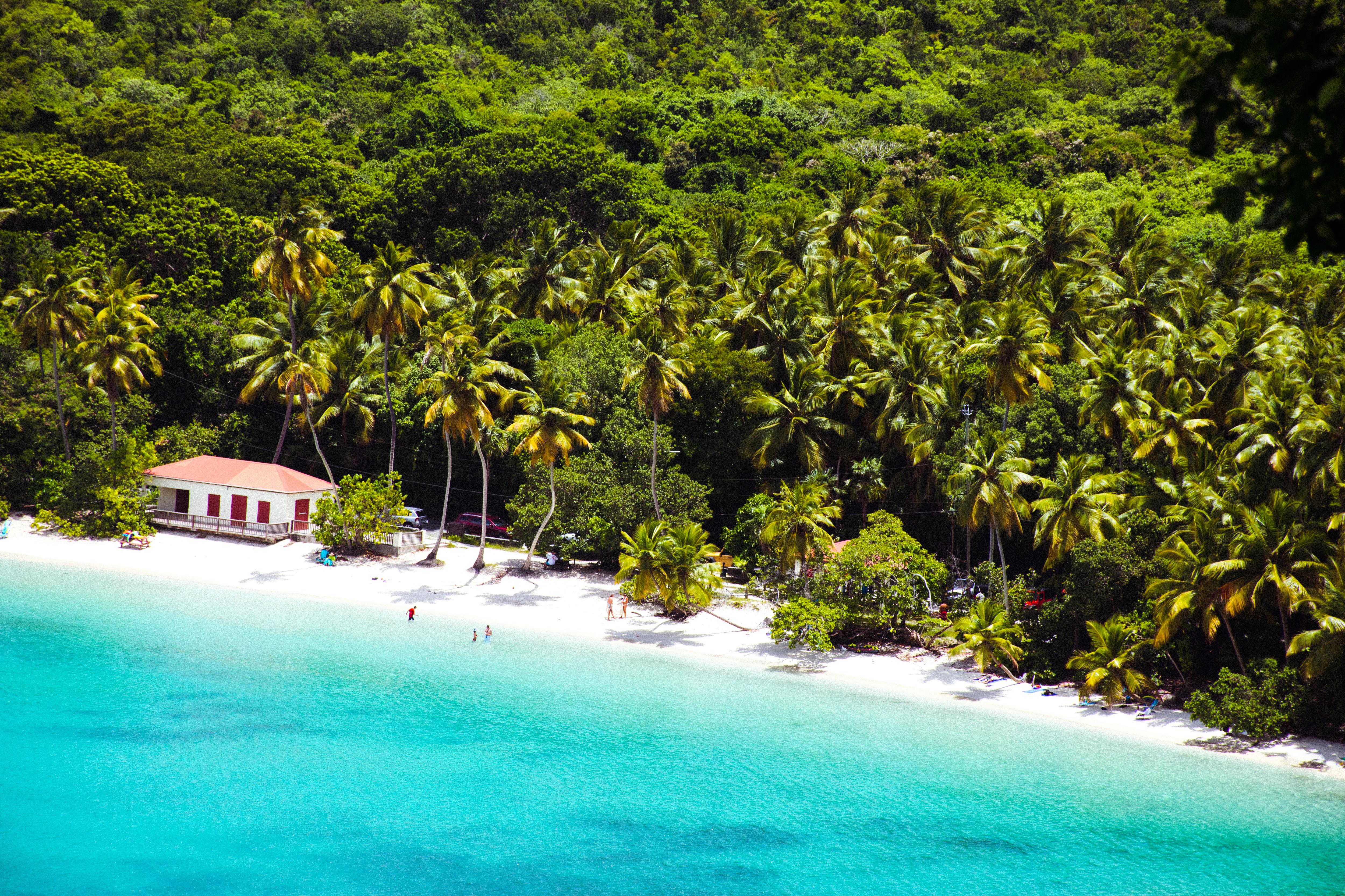 Smuggler’s Bay Beach in Tortola, BVI—secluded white sand, calm turquoise water, and a lush coastal backdrop make it a hidden Caribbean escape for private yacht guests | Fraser Yachts