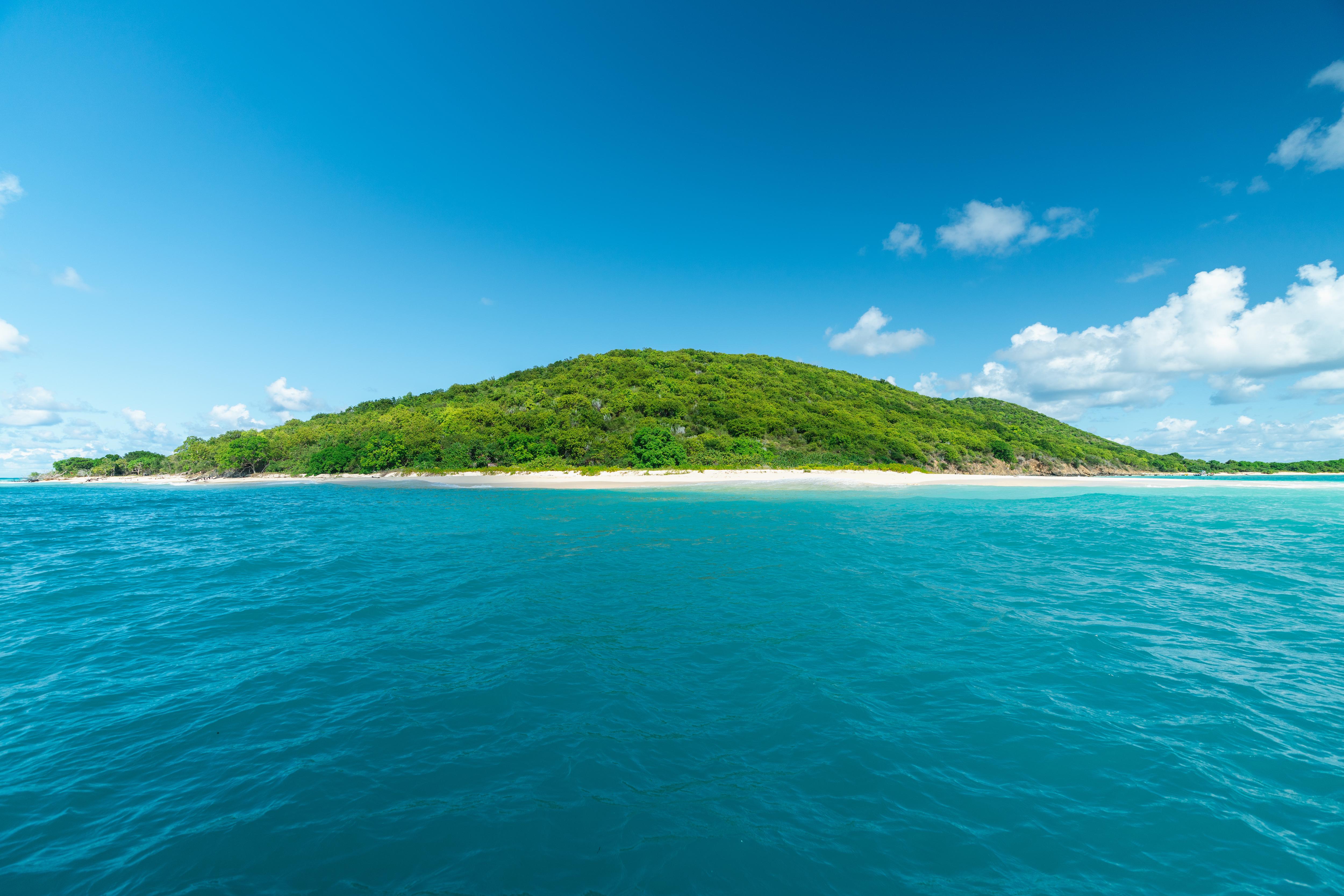 View of Buck Island off St. Croix, US Virgin Islands—lush green hills and turquoise waters create a serene setting for beach visits, snorkeling, and island exploration | Fraser Yachts