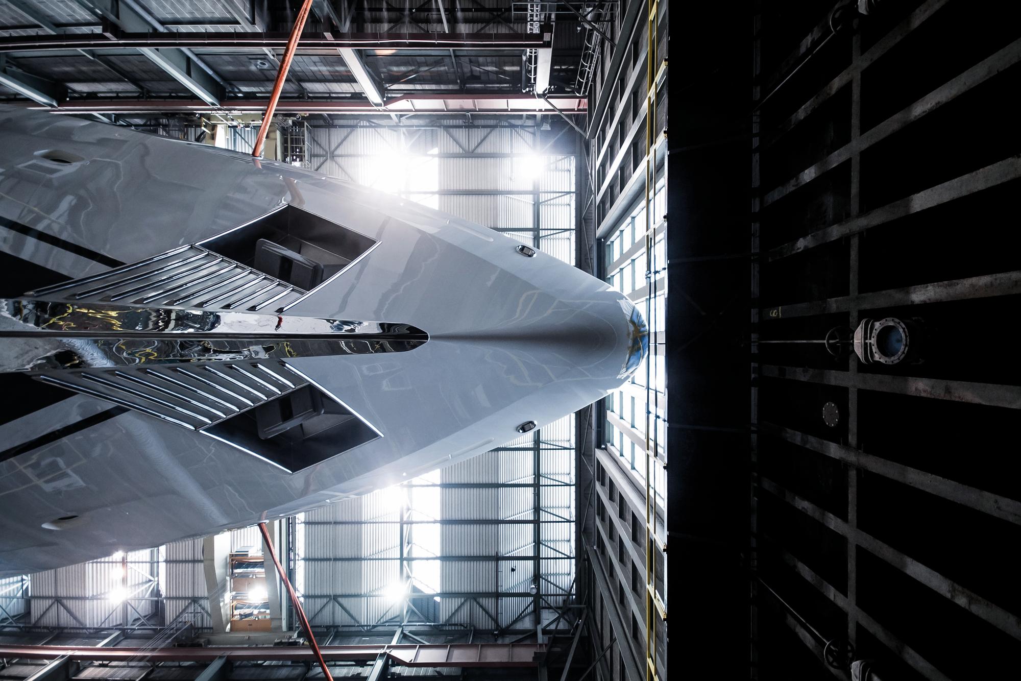 A front view from underneath a yacht during the construction phase, showcasing the intricate details of the build process. | yacht construction, boat building, yacht design, underboat view | Fraser Yachts