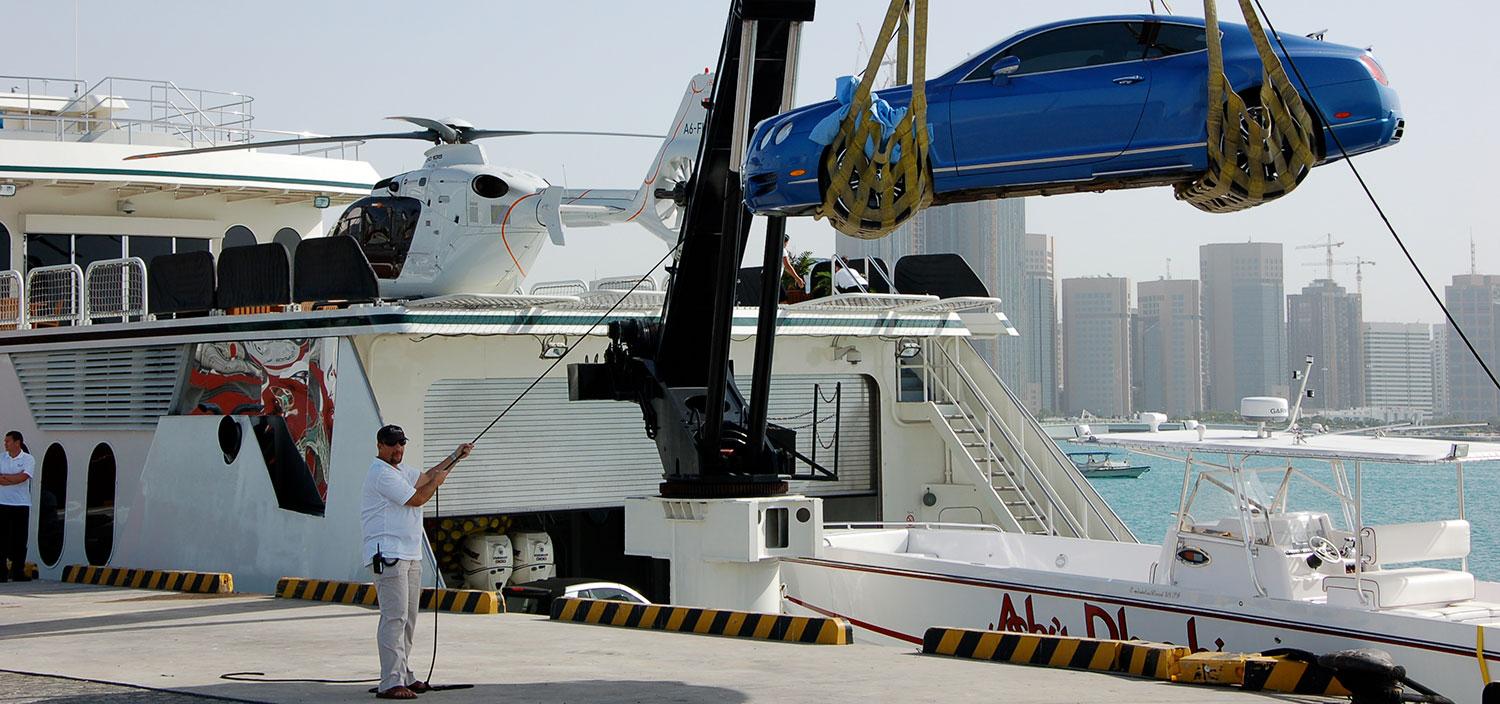 A car being lifted during the yacht construction process, illustrating the integration of automotive technology in luxury yacht builds. | yacht construction, car lift, luxury yacht, automotive integration | Fraser Yachts