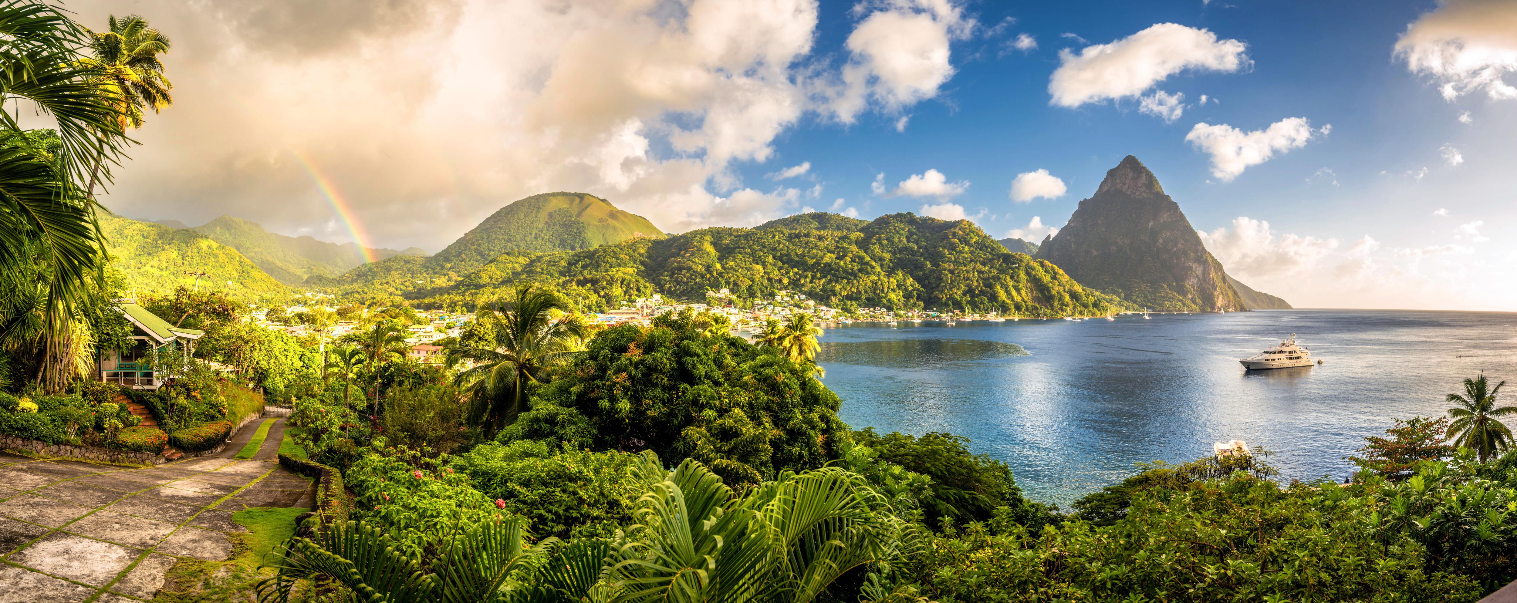 Panoramic view of SoufriĆØre Bay and the Pitons in Saint Luciaālush rainforest, iconic peaks, and a serene bay make this Caribbean gem perfect for luxury yacht charters | Fraser Yachts