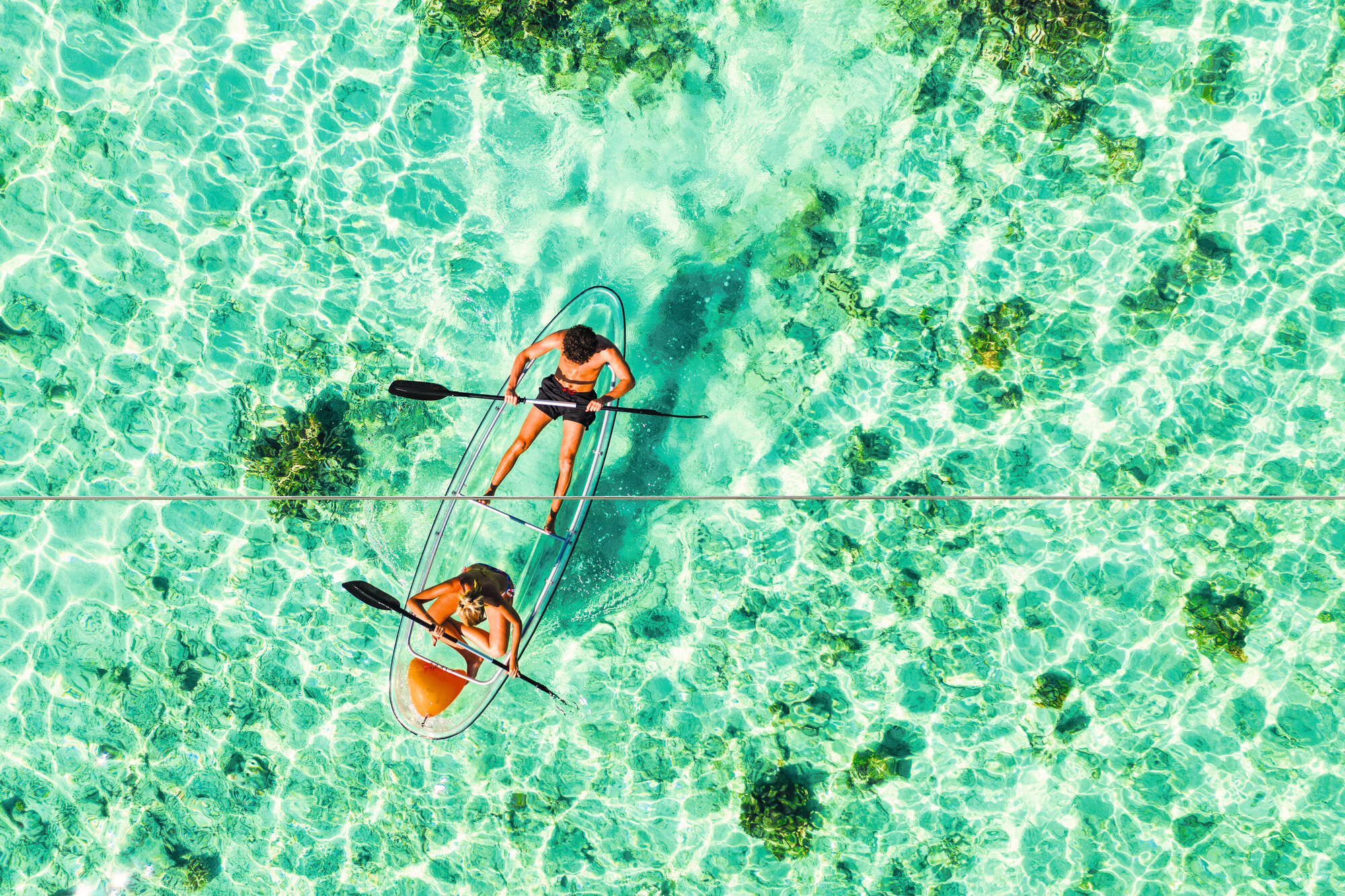 Enjoy an aerial view of a couple canoeing in the transparent waters of the Maldives | Maldives, aerial view, canoeing, transparent water | Fraser