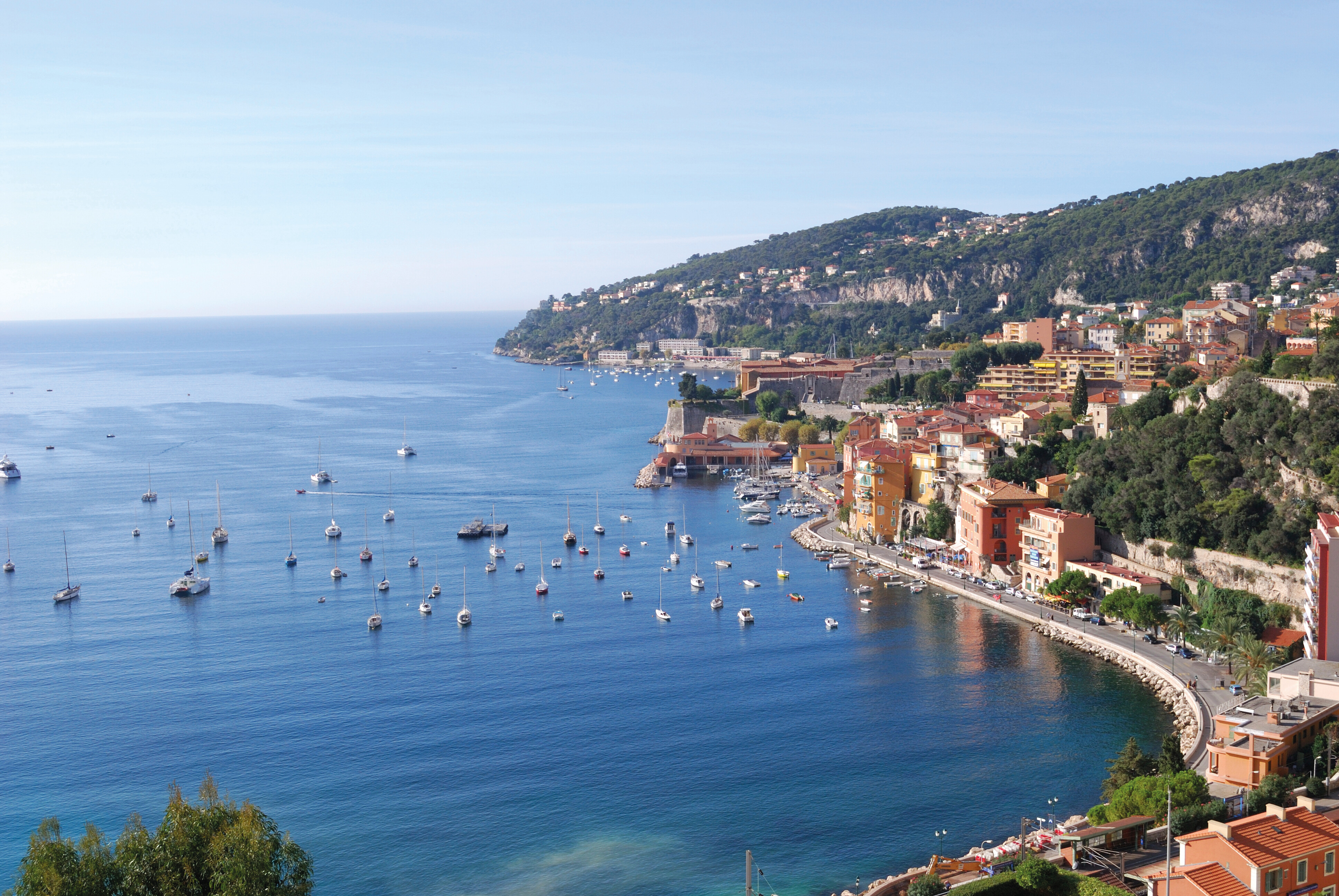 Scenic view of Villefranche-sur-Mer, a picturesque coastal town on the French Riviera, featuring colorful Mediterranean buildings and sailboats in the bay