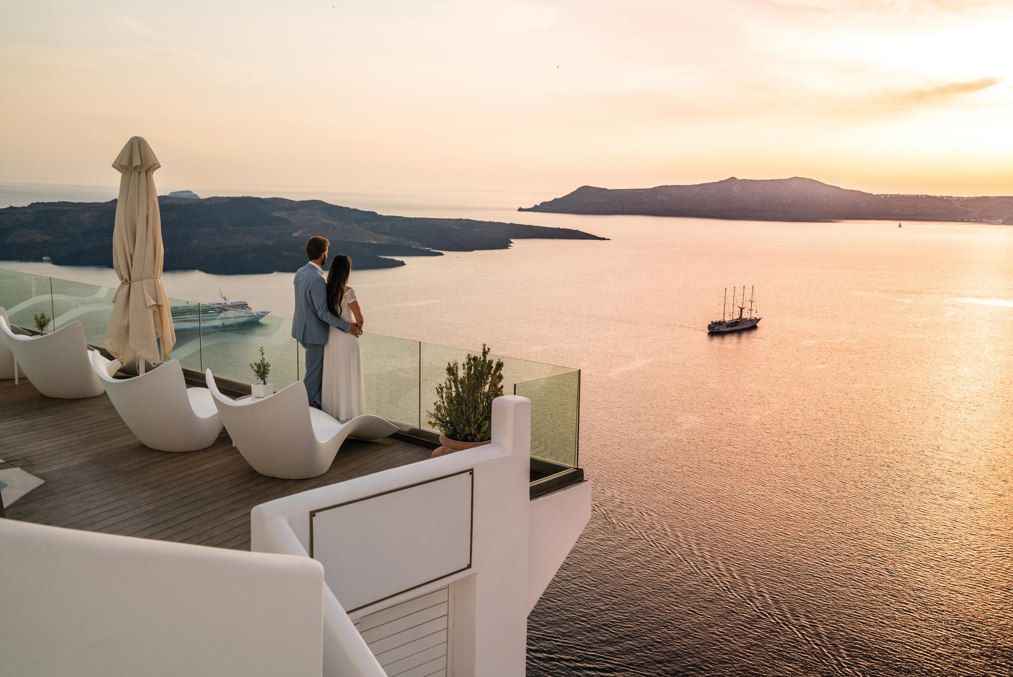 Experience romance on the terrace overlooking the sea in Santorini, Greece, with Fraser Yachts. | Mediterranean, Greece, Santorini, couple, terrace, sea view, yacht charter | Fraser