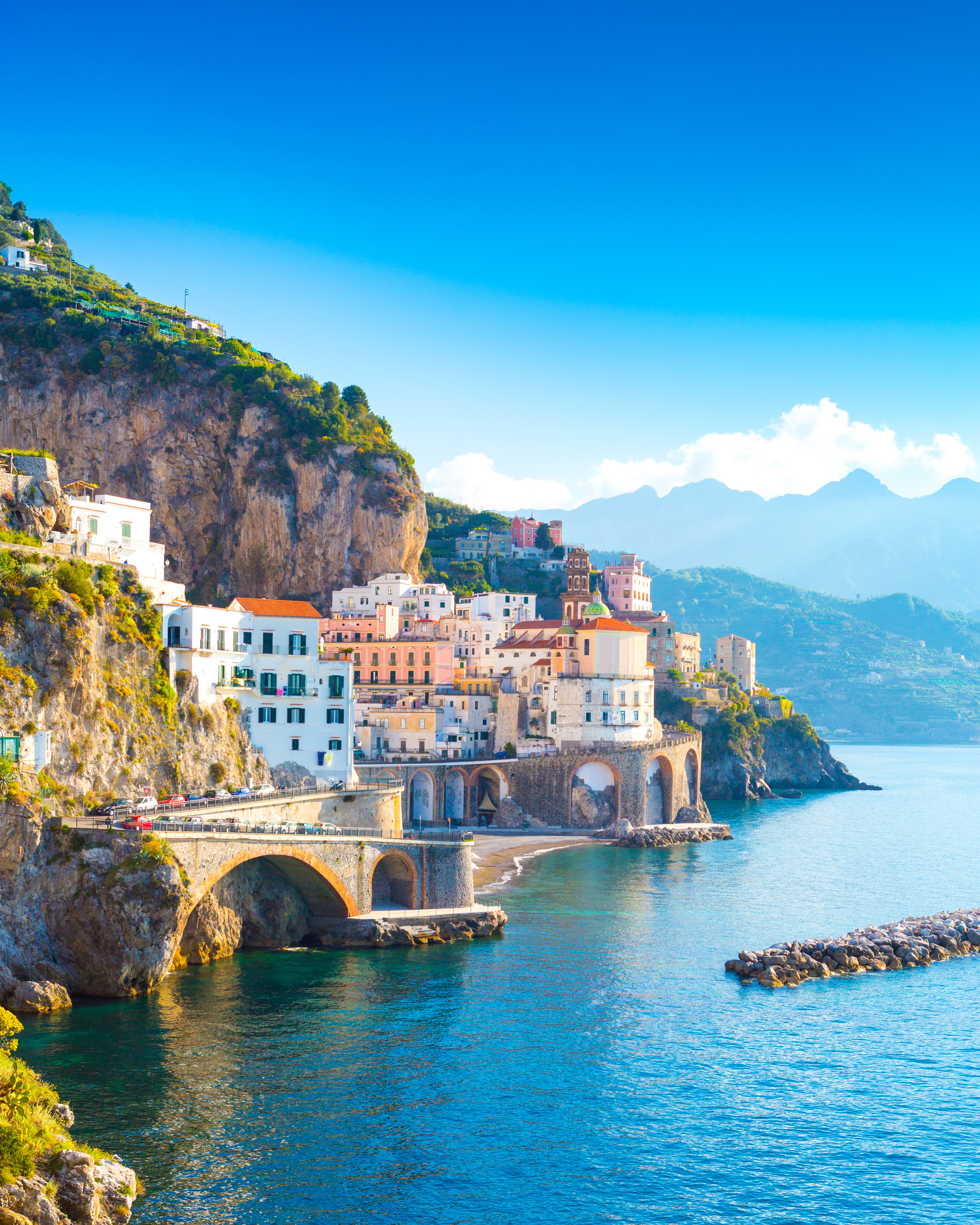 Amalfi town on the Amalfi Coast, Italy—historic buildings and coastal arches set against turquoise waters, a timeless Mediterranean destination for luxury yacht cruising | Fraser Yachts