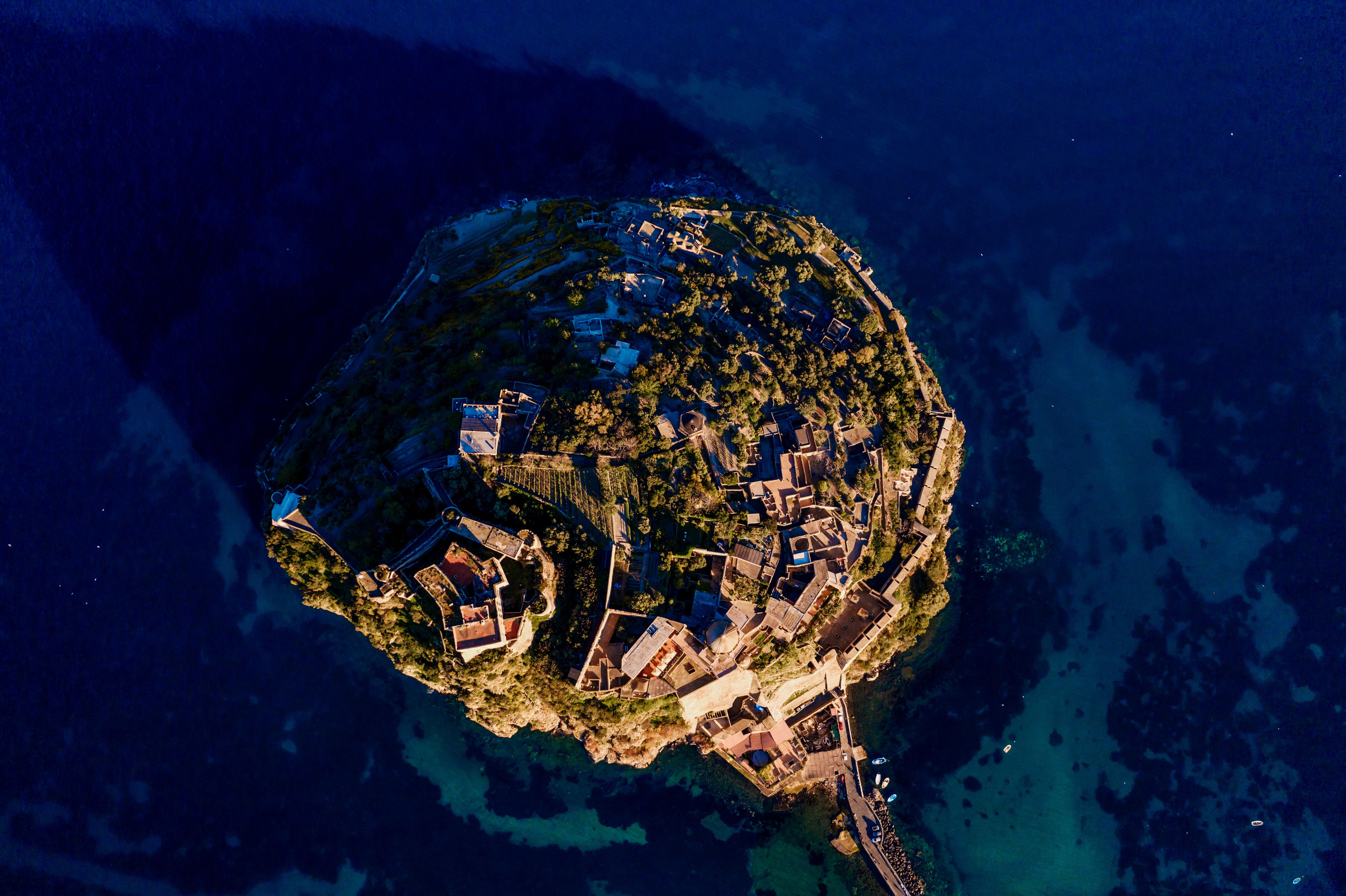 Aerial view of Procida near Ischia, Italy—vivid island colors surrounded by deep blue waters, a picturesque Mediterranean destination for yacht cruising | Fraser Yachts