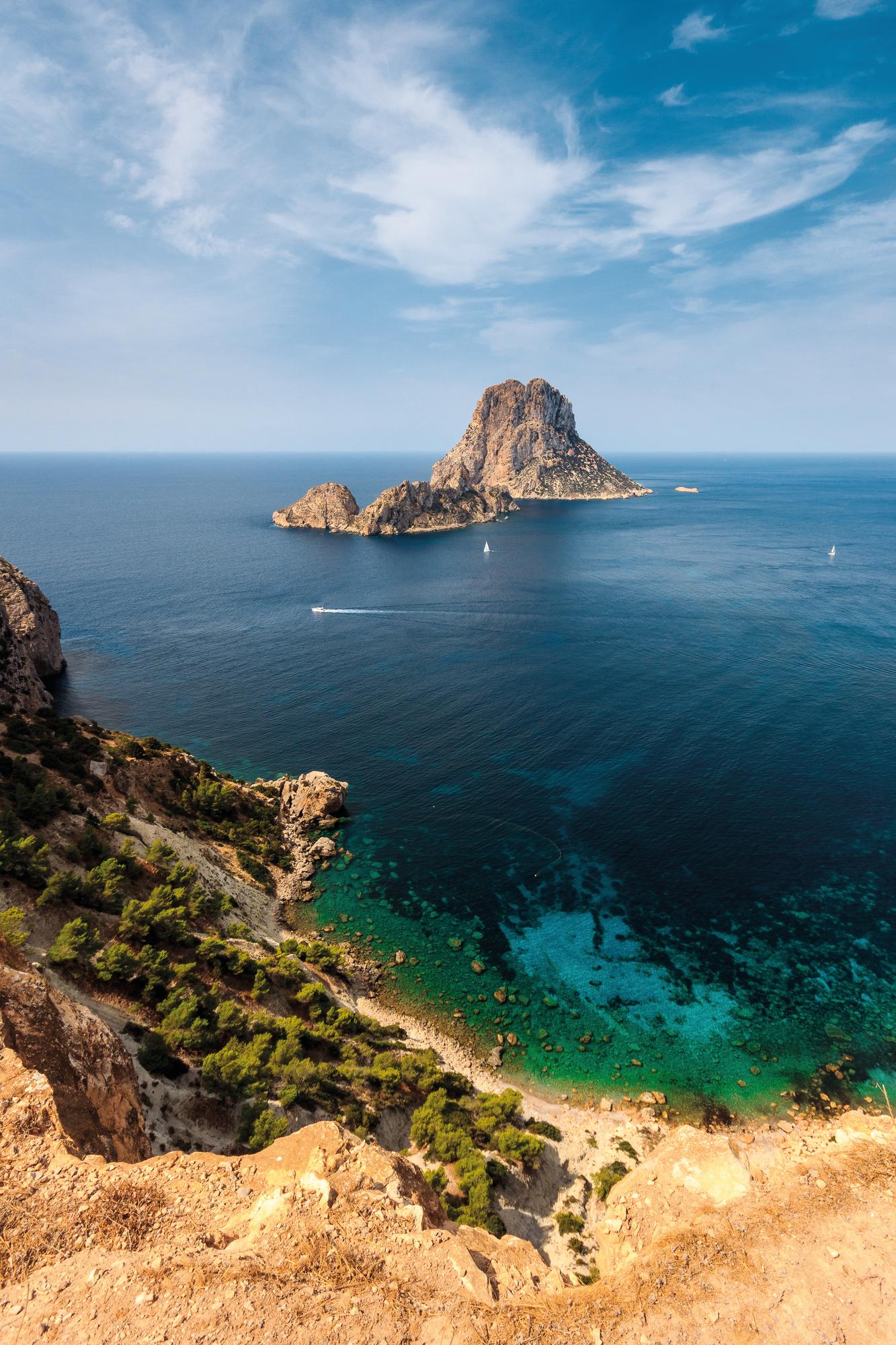 Explore the breathtaking beauty of Es Vedrà, Ibiza, Spain, with Fraser Yachts. | Mediterranean, Spain, Ibiza, Es Vedrà, yacht charter | Fraser