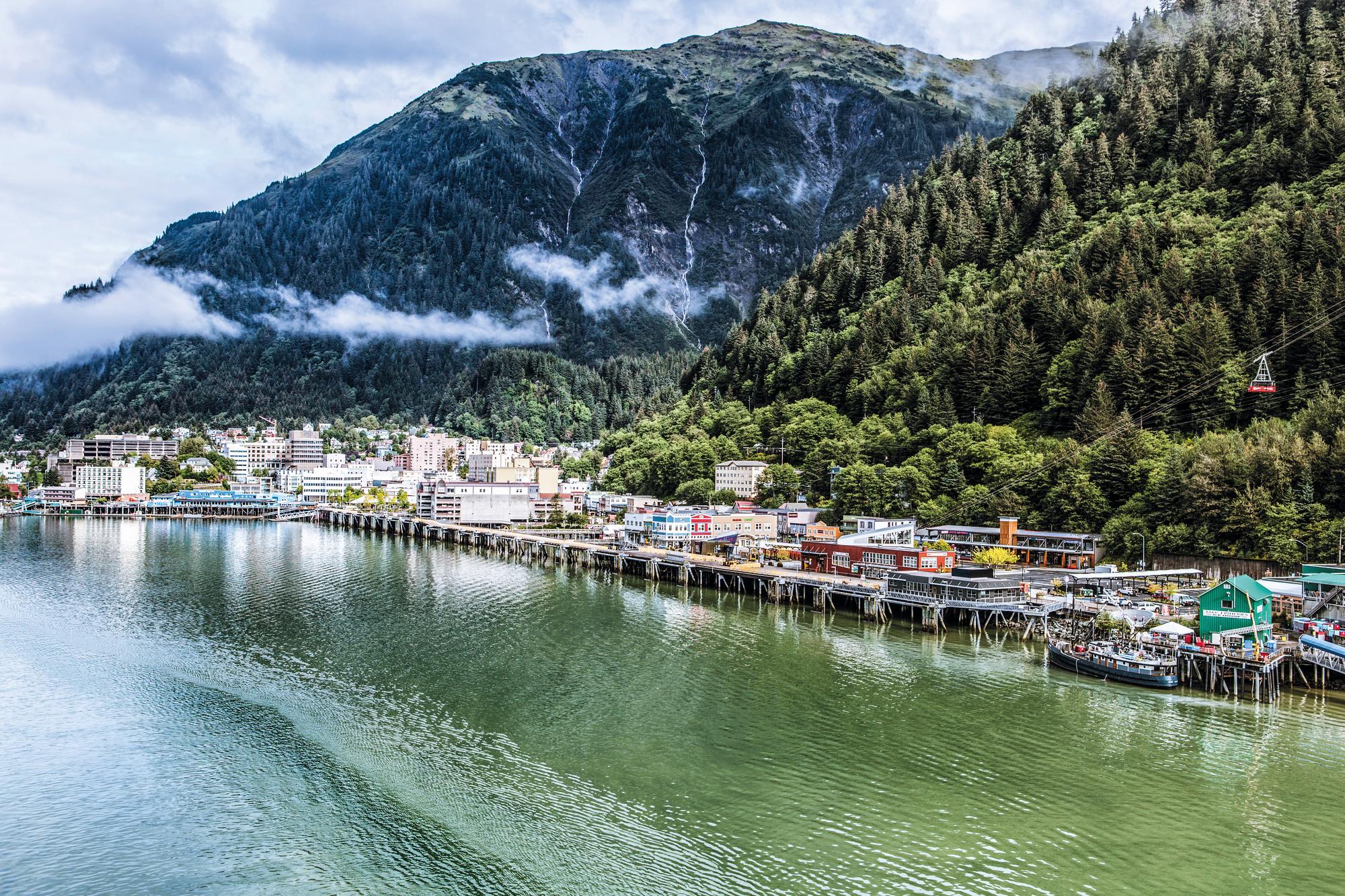 Explore the scenic landscapes of Juneau, Alaska with its lush trees and majestic mountains | North America, Alaska, Juneau, landscape, trees, mountains, clouds | FRASER