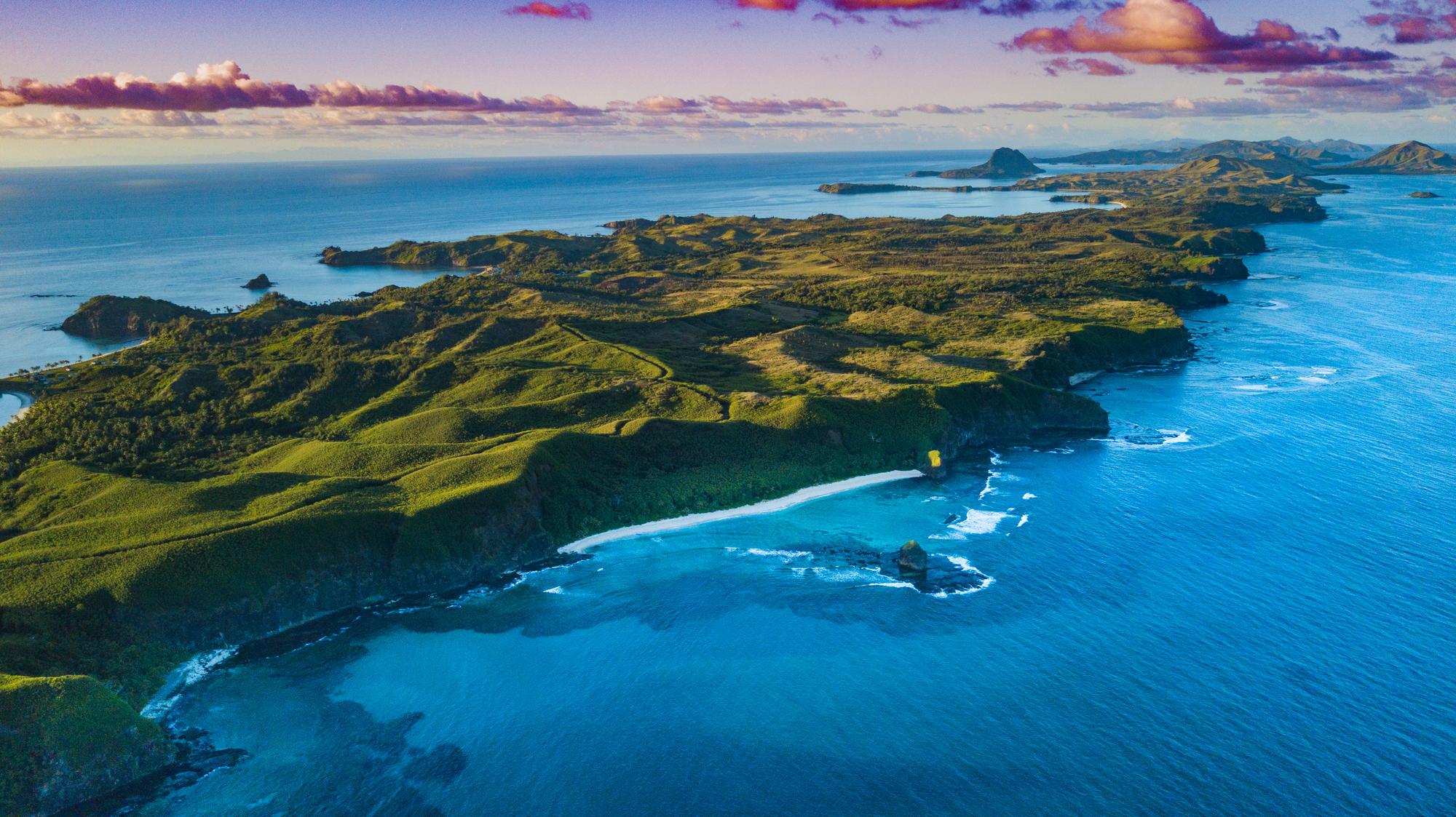 Take in the stunning aerial view of Fiji’s tropical coastline and beach, showcasing a picturesque ocean landscape | Aerial, Beach, Clouds, Coastline, Ocean, Landscape, Tropical | Fraser