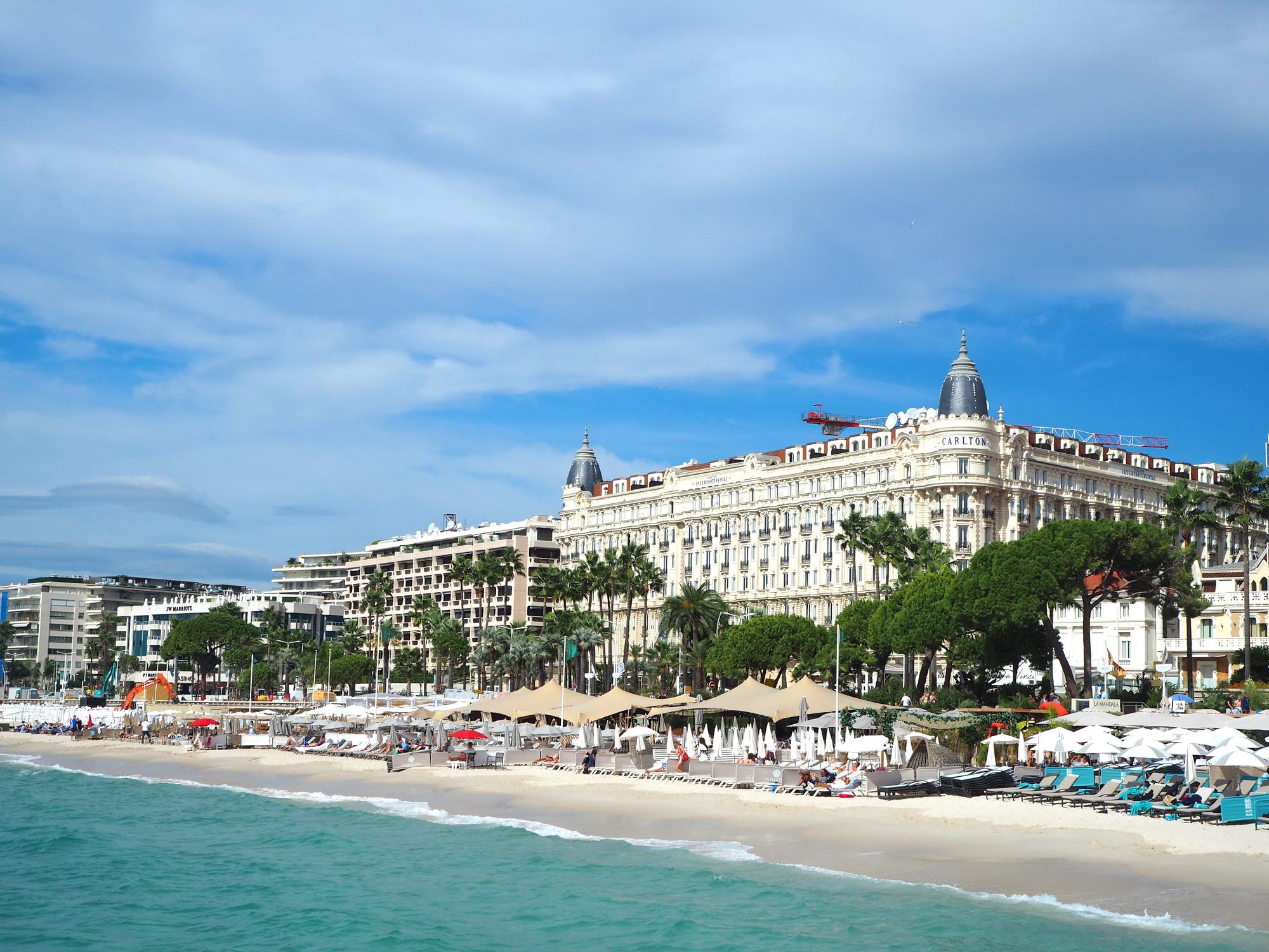 Bask in luxury while sunbathing along La Croisette at the iconic Carlton Hotel in Cannes, France, a glamorous experience on the Mediterranean itinerary. | La Croisette, Cannes, Carlton Hotel, sunbathing, Mediterranean itinerary, Fraser Yachts | fraser