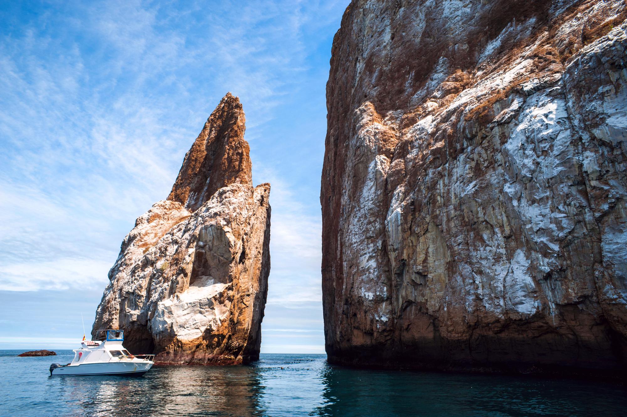 Admire the striking cliffs of Kicker Rock on San Cristóbal Island, showcasing the unique climate and dramatic scenery of the Galapagos Islands | Kicker Rock, San Cristóbal, Climate, Landscape, Galapagos | Fraser