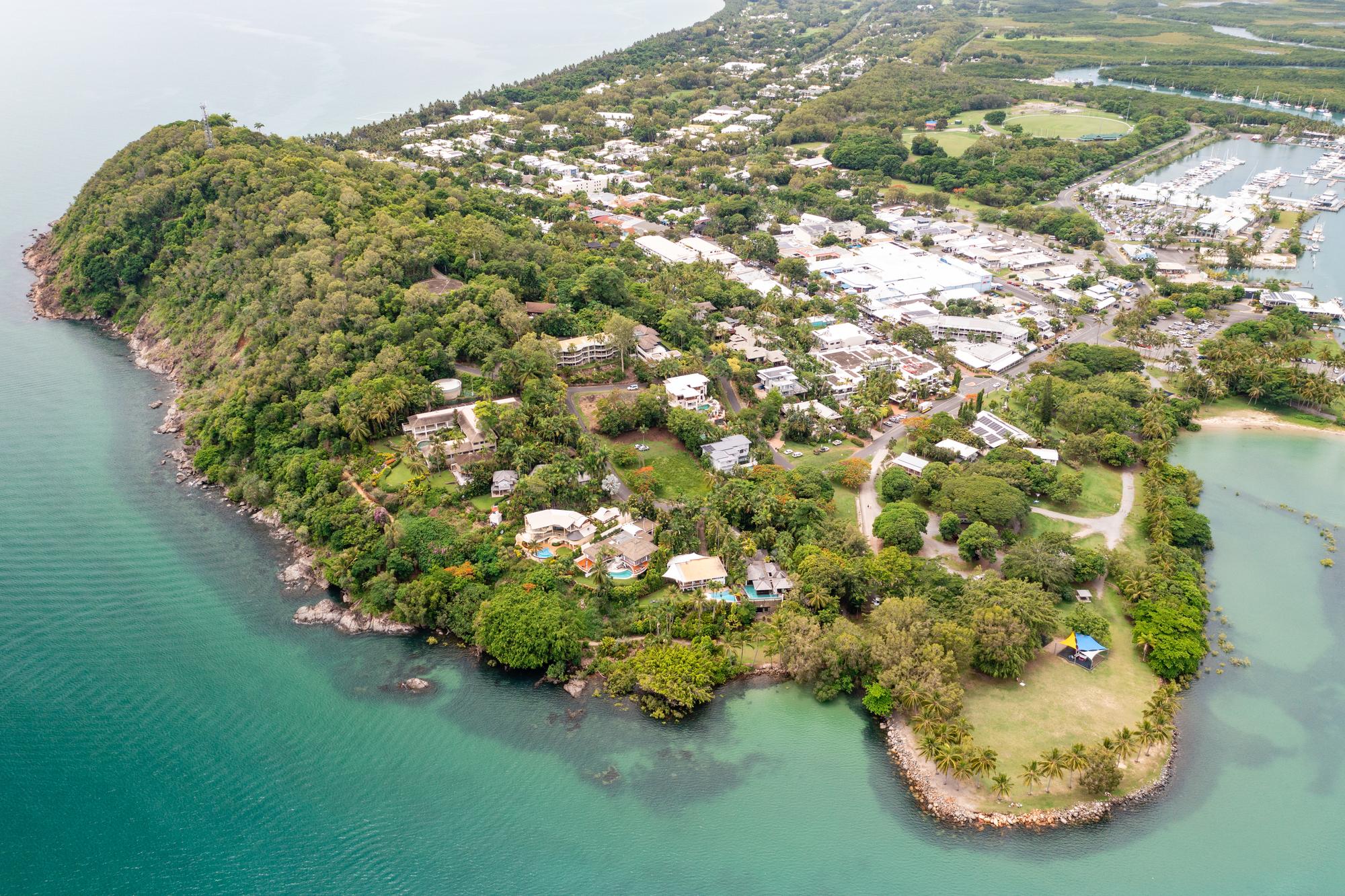 Discover the lush forest and charming town of Port Douglas from above, a gateway to the Great Barrier Reef’s natural beauty | Forest, lush, aerial, town | Fraser