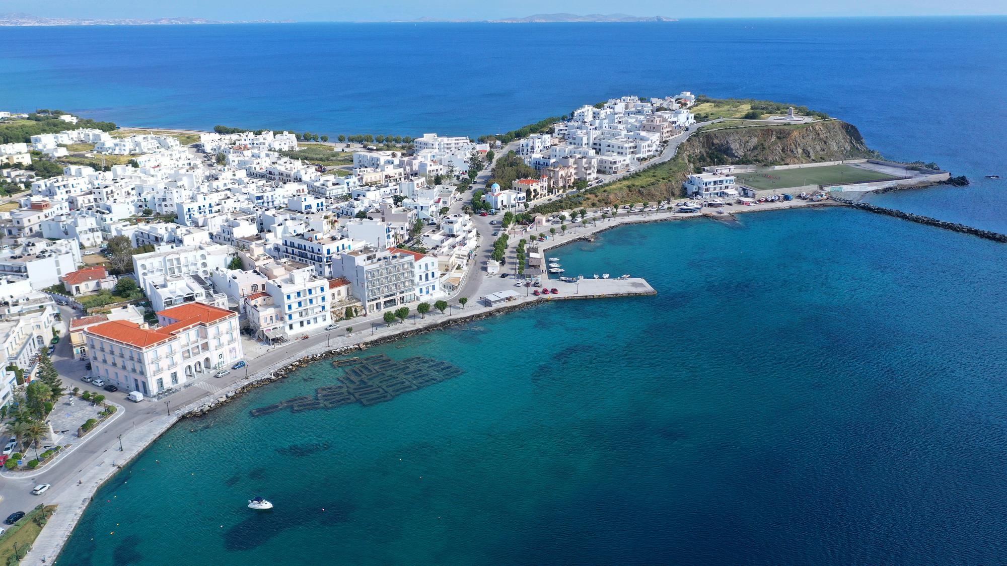 Experience an aerial view of Tinos, Greece, a stunning highlight in the Mediterranean itinerary. | Tinos aerial view, Mediterranean Greece itinerary, Greek islands, Fraser Yachts | fraser