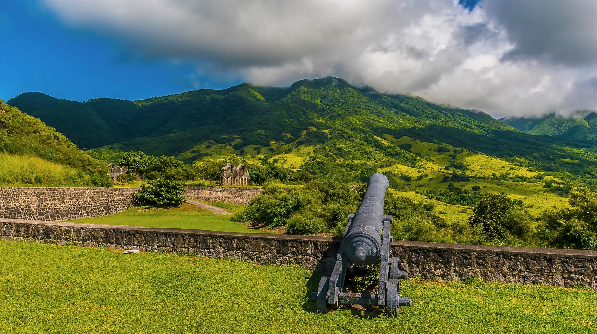 Immerse yourself in the lush greenery of the rainforest in Saint Kitts, where historic forts and cannons dot the landscape, creating an idyllic holiday escape | Fort, forest, green, cannon, island, holiday, Saint Kitts | FRASER