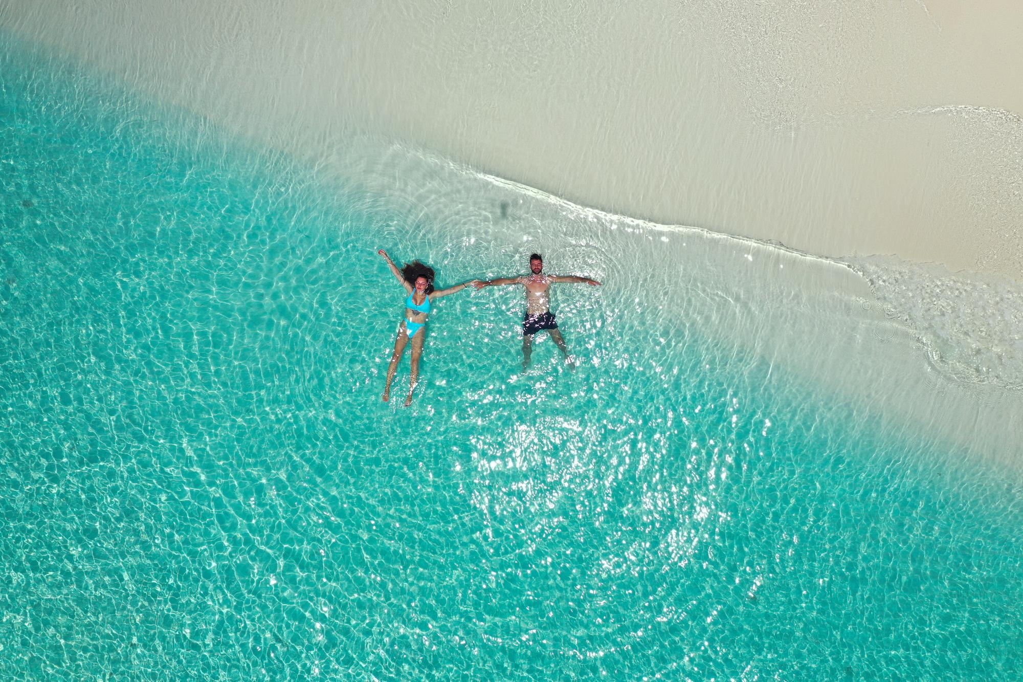 Discover a serene beachside retreat in the Maldives from above, ideal for a romantic honeymoon with peaceful views and tropical beauty. | Aerial, Beach, Honeymoon, Couple, Exotic, Peace, Romantic, Seaside | Fraser