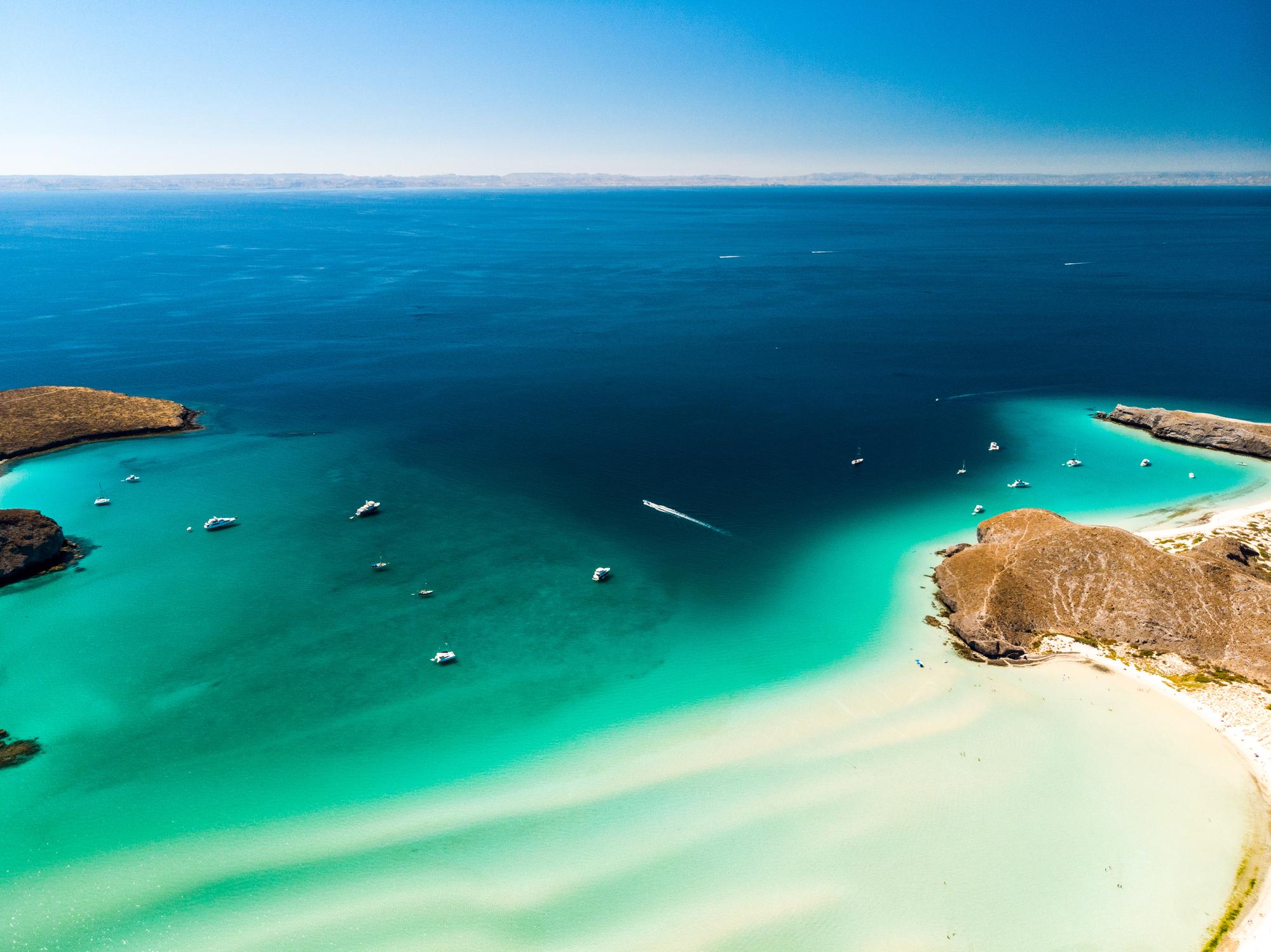 Take in the breathtaking aerial view of Balandra Beach in La Paz, featuring clear waters and a stunning sky | Aerial View, Beach, Clear Sky, Balandra Beach | Fraser