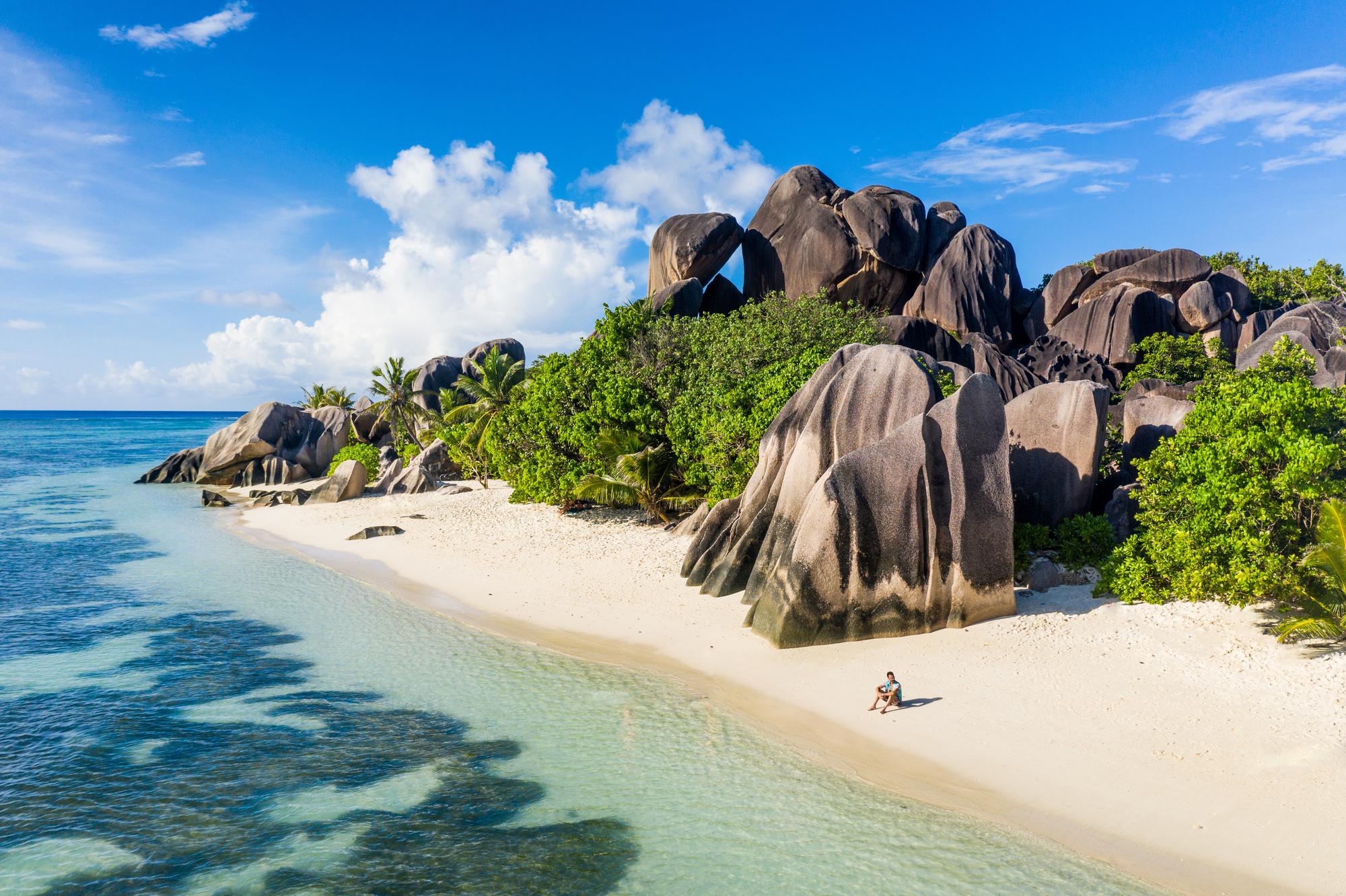 Explore La Digue's exotic beach with its iconic granite rocks and sandy shores, a perfect destination for travelers. | Granite, Rocks, Sand, Exotic, Beach, Traveler, Seychelles | Fraser