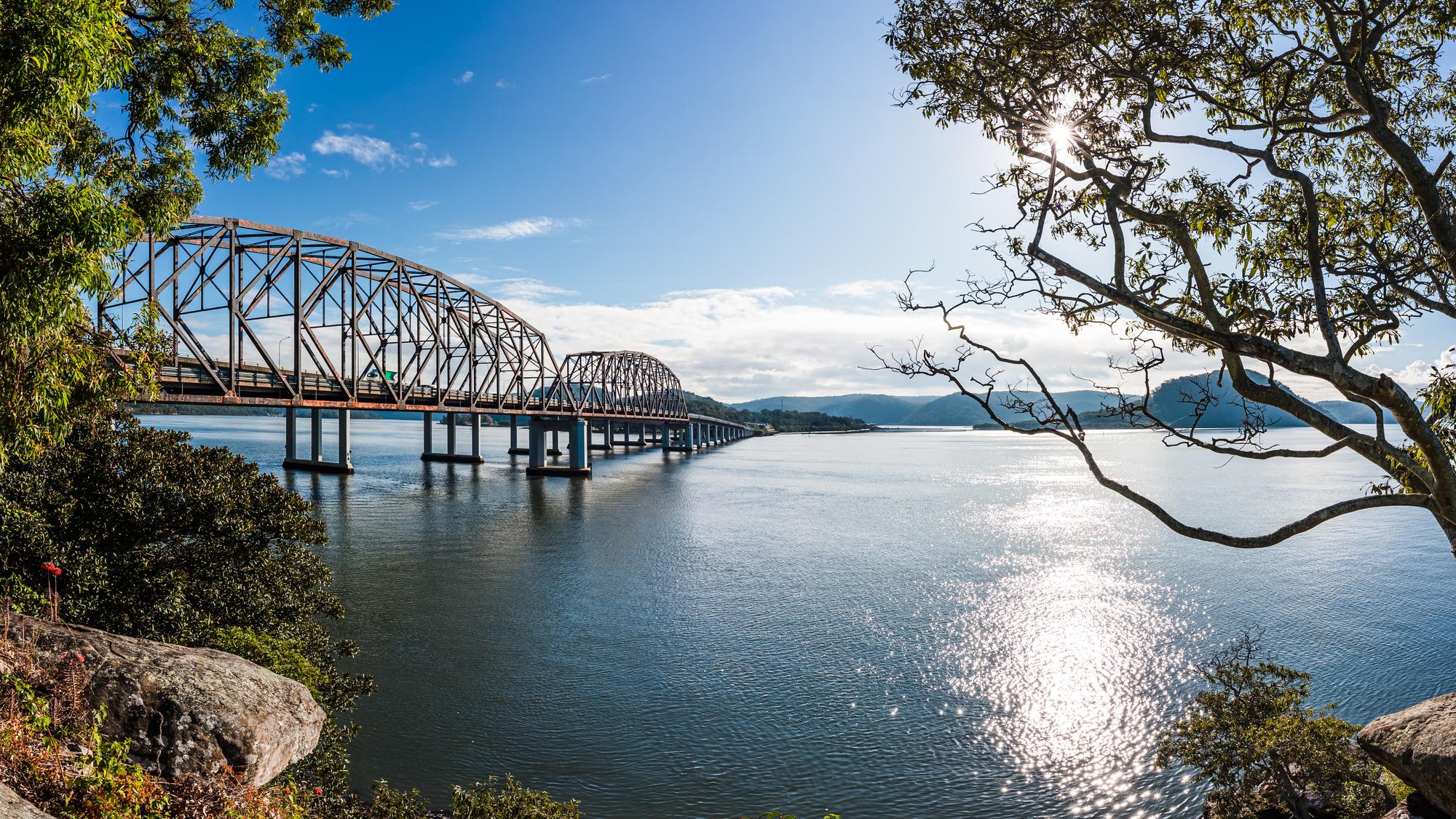 Hawkesbury River: View of a man-made highway crossing the river with steel structures and sunlight | Highway, Into the Sun, Man-Made, River, Road, Steel, Sunlight, Traffic | Fraser