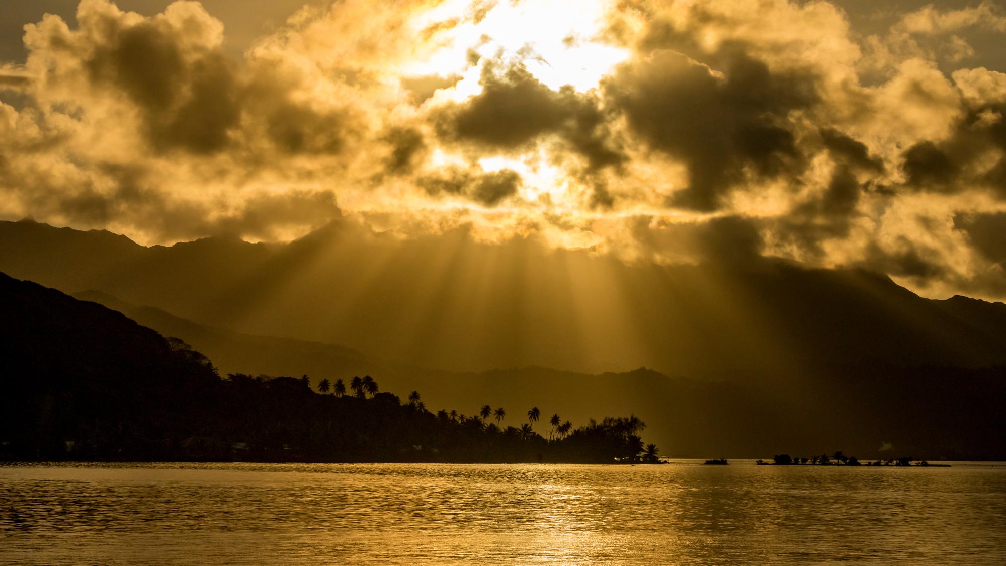 Bask in the golden rays of the sun over the tropical paradise of Raiatea, showcasing a stunning seascape in French Polynesia | Sun, Rays, Paradise, Tropical, Seascape, Golden | Fraser